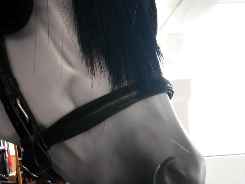 weiße Pferdeattrappe mit schwarzem Kopfstück mit Scheuklappen